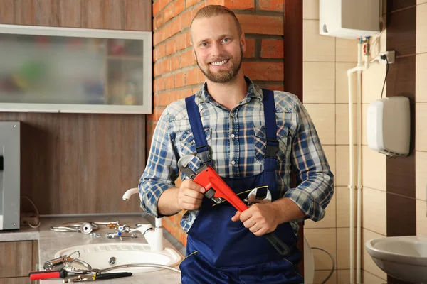 Portrait of handsome plumber with pipe wrench — Stock Photo, Image