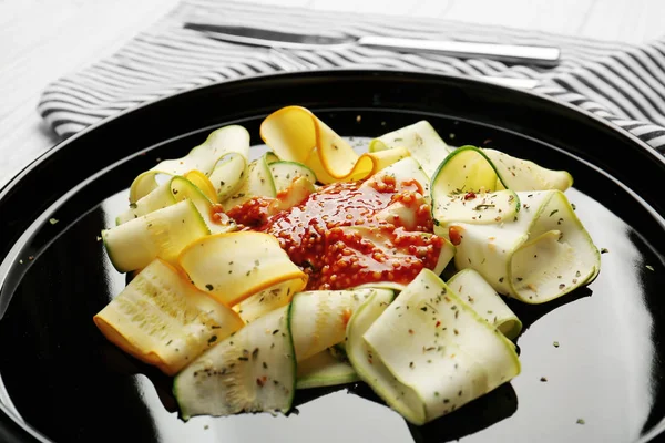 Fette di zucchine con condimento su piatto nero — Foto Stock