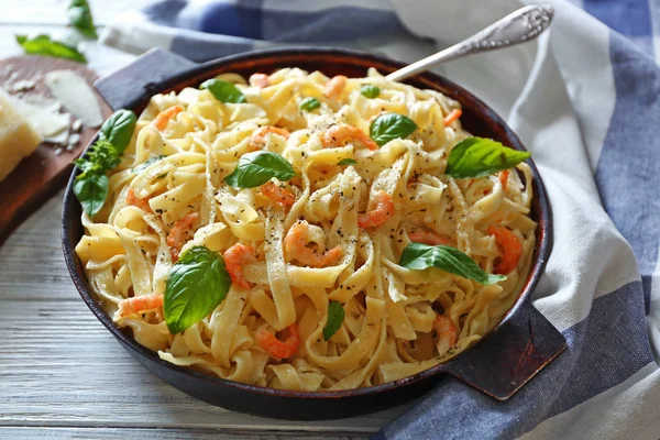 Pan met lekkere alfredo pasta en servet op houten tafel — Stockfoto