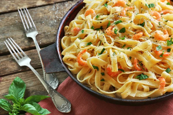 Pan met lekkere alfredo pasta en vorken op houten tafel — Stockfoto