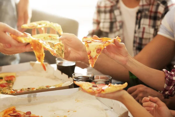 Друзі їдять піцу на домашній вечірці, крупним планом — стокове фото