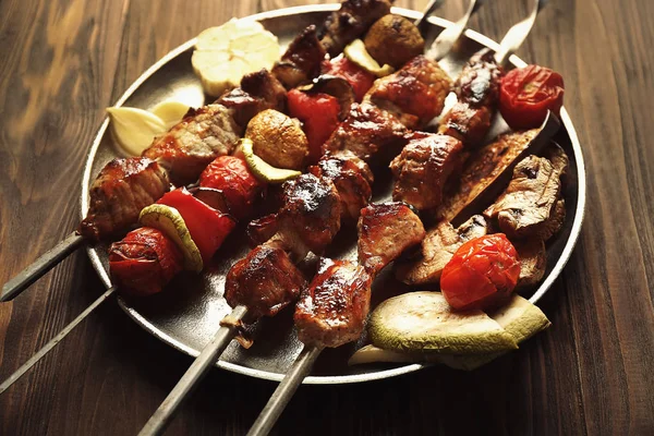 Fresh tasty barbecue with vegetables on tray on wooden background — Stock Photo, Image