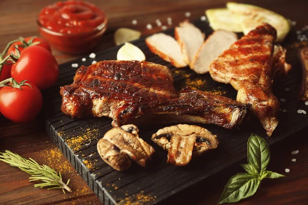 Carne a la parrilla con verduras sobre tabla de cortar sobre fondo de madera — Foto de Stock