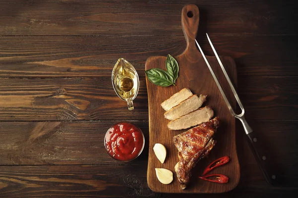 Viande grillée aux épices sur planche à découper sur fond bois — Photo