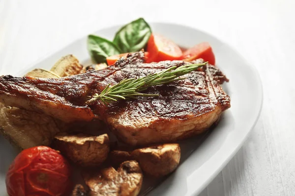 Carne grelhada com legumes no prato, close-up — Fotografia de Stock