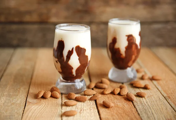 Молочные коктейли с миндалем на деревянном столе — стоковое фото