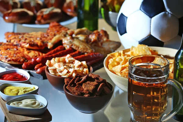 Bola, cerveja e lanches saborosos na mesa da cozinha, vista de perto — Fotografia de Stock