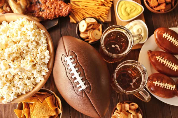 Table full of tasty snacks and beer prepared for watching rugby on TV — Stock Photo, Image