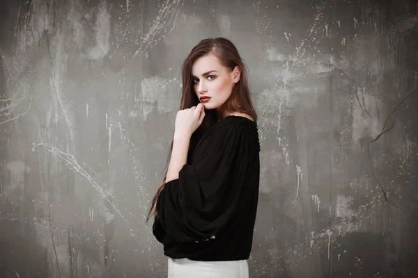 Stijlvolle jongedame in zwarte shirt met trendy make-up op grijze achtergrond — Stockfoto