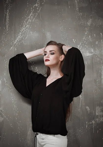 Jovem mulher elegante em camisa preta com maquiagem moderna em fundo cinza — Fotografia de Stock