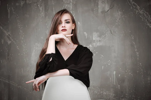 Mujer hermosa joven en camisa negra con hermoso maquillaje posando sobre fondo gris —  Fotos de Stock