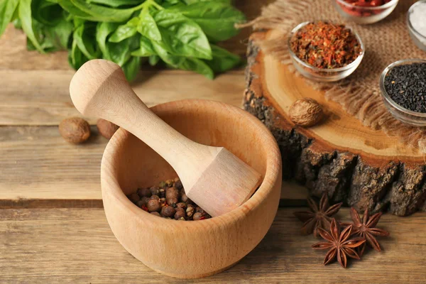 Composition with different spices and mortar on wooden background — Stock Photo, Image
