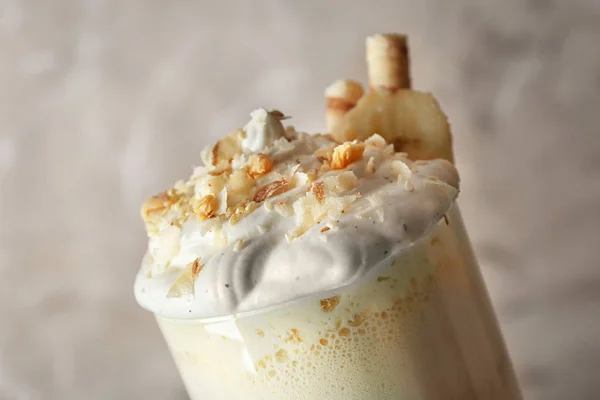 Läcker banan milkshake med godis på beige bakgrund, närbild — Stockfoto