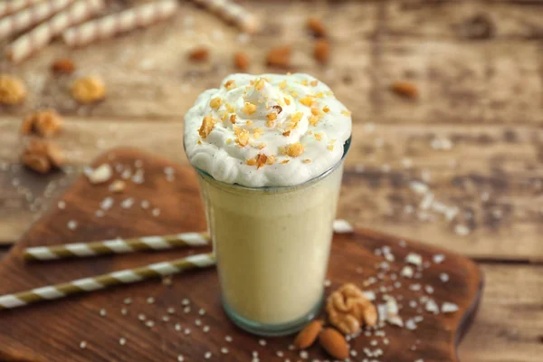 Glass of delicious nut milkshake on wooden background — Stock Photo, Image