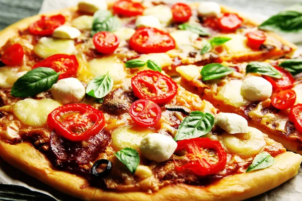 Fresh pizza with tomatoes and basil on table closeup — Stock Photo, Image