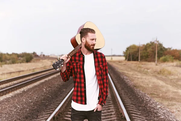 Bel homme avec guitare sur rail — Photo