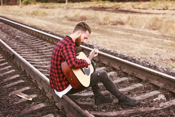 Bell'uomo che suona la chitarra su ferrovia — Foto Stock