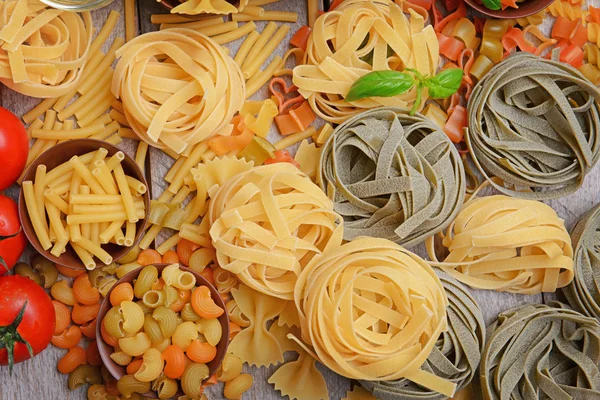 Різні види макаронних виробів і томатів — стокове фото