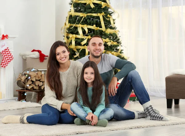 Aile halı oturma odasında oturup Noel için dekore edilmiş — Stok fotoğraf