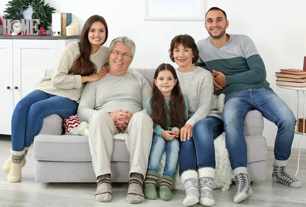 Familia feliz sentado en el sofá en la sala de estar — Foto de Stock