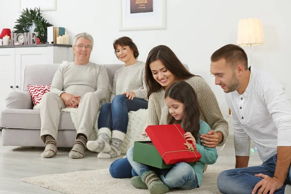 Feliz chica abriendo regalo de Navidad de sus padres — Foto de Stock