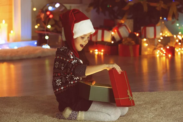 Meisje openen kerstcadeau in woonkamer — Stockfoto