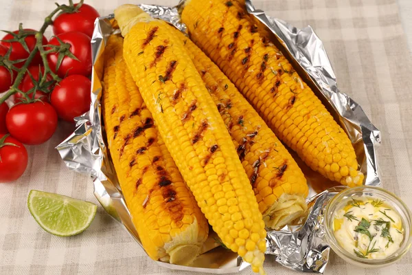 Grilled corns with cherry tomatoes and ingredients on table — Stock Photo, Image