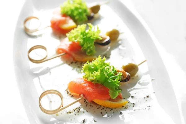 Set of delicious canapes on white plate closeup — Stock Photo, Image