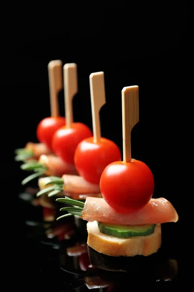 Set of delicious canapes on black background — Stock Photo, Image