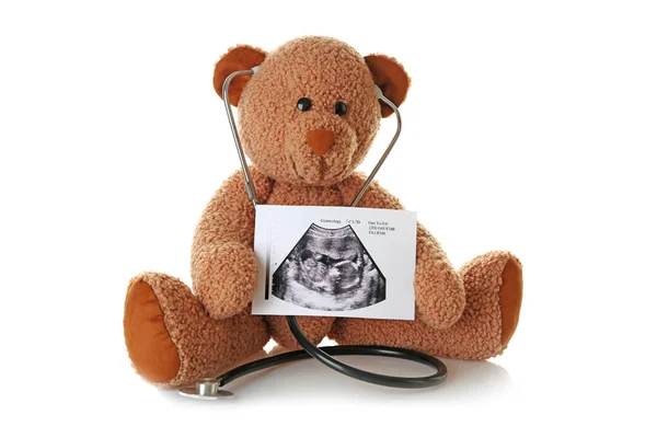 Teddybeer met echografie van baby- en stethoscoop op witte achtergrond — Stockfoto