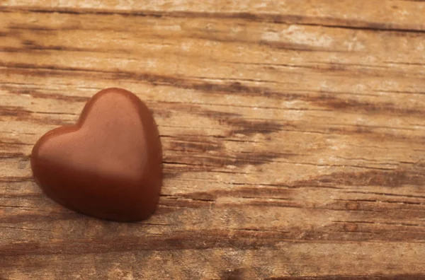 Coração de chocolate no fundo de madeira — Fotografia de Stock