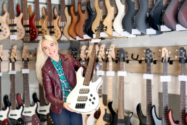Vrouwelijke verkoopster gitaar te houden in de winkel — Stockfoto