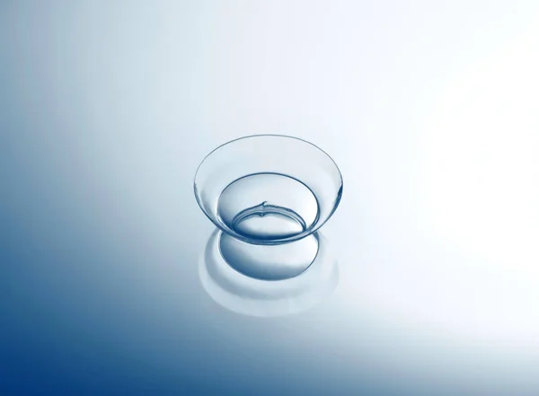 Contactlens op soepele lichte achtergrond, close-up. Geneeskunde en visie concept — Stockfoto