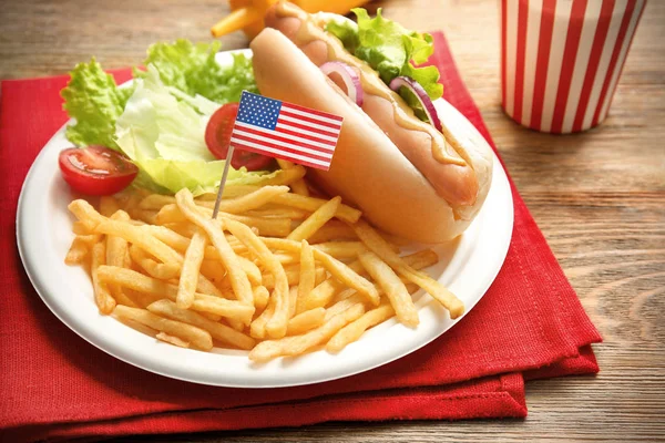 Hot dog con patatine fritte e piccola bandiera USA sul piatto — Foto Stock