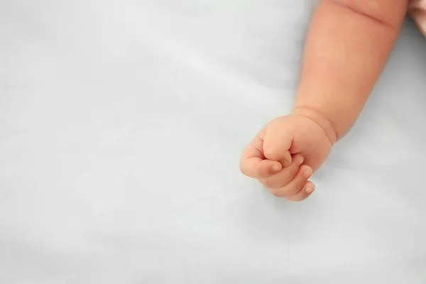 赤ちゃんの手のクローズ アップのベッドの上 — ストック写真