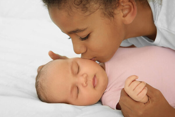 Girl kissing her little sister, closeup