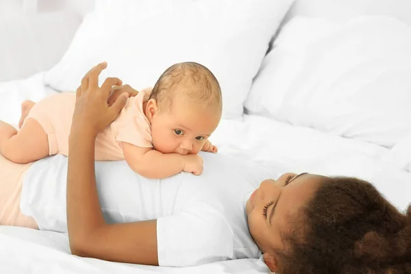 Lindo bebé y hermana mayor en la cama —  Fotos de Stock
