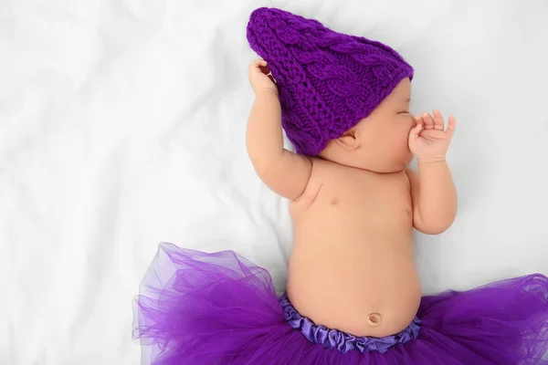 Bebê bonito em saia roxa dormindo na cama — Fotografia de Stock