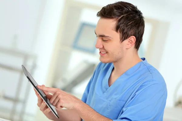 Jovem médico do sexo masculino com tablet no escritório — Fotografia de Stock