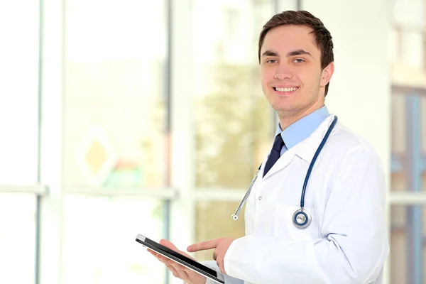 Jeune médecin masculin avec tablette au bureau — Photo