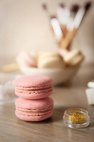 Macaroons saborosos e acessórios de beleza na mesa, close-up — Fotografia de Stock