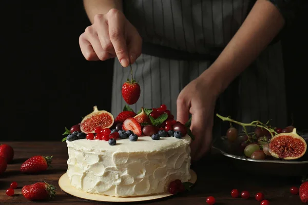 Baker hand decorating creamy cake — Stock Photo, Image