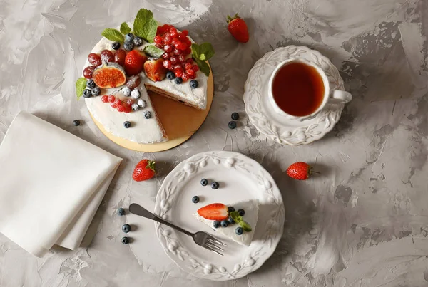 Pedaço de bolo delicioso com bagas na mesa cinza, vista superior — Fotografia de Stock