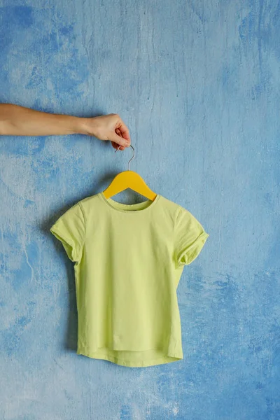 Mão segurando t-shirt verde em branco — Fotografia de Stock