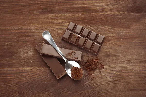 Broken chocolate pieces and spoon — Stock Photo, Image