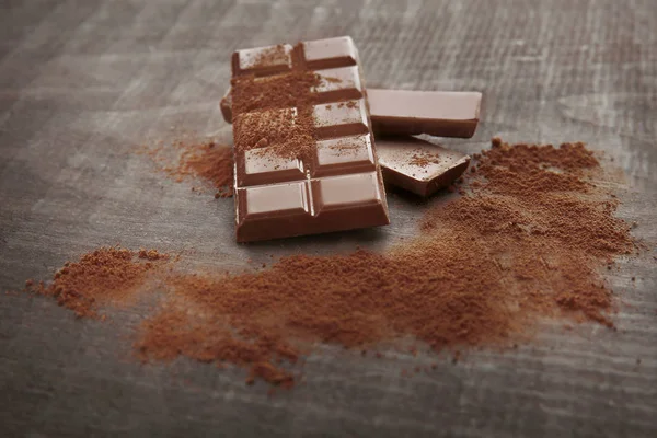 Broken chocolate pieces and cocoa powder — Stock Photo, Image