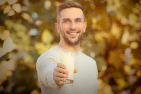 Νεαρός άνδρας με γυάλινο φρέσκου γάλακτος εξωτερική — Φωτογραφία Αρχείου