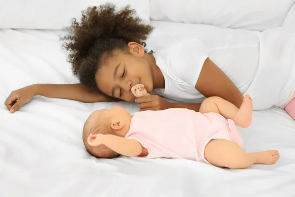 Cute baby and elder sister on bed — Stock Image Cute baby and elder sister on bed Stock Image