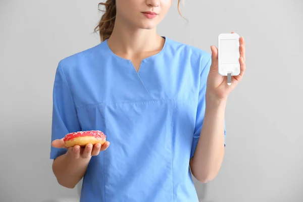 Médecin féminin avec beignet — Photo