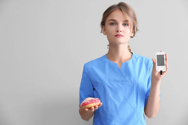 Female doctor with donut — Stock Photo, Image